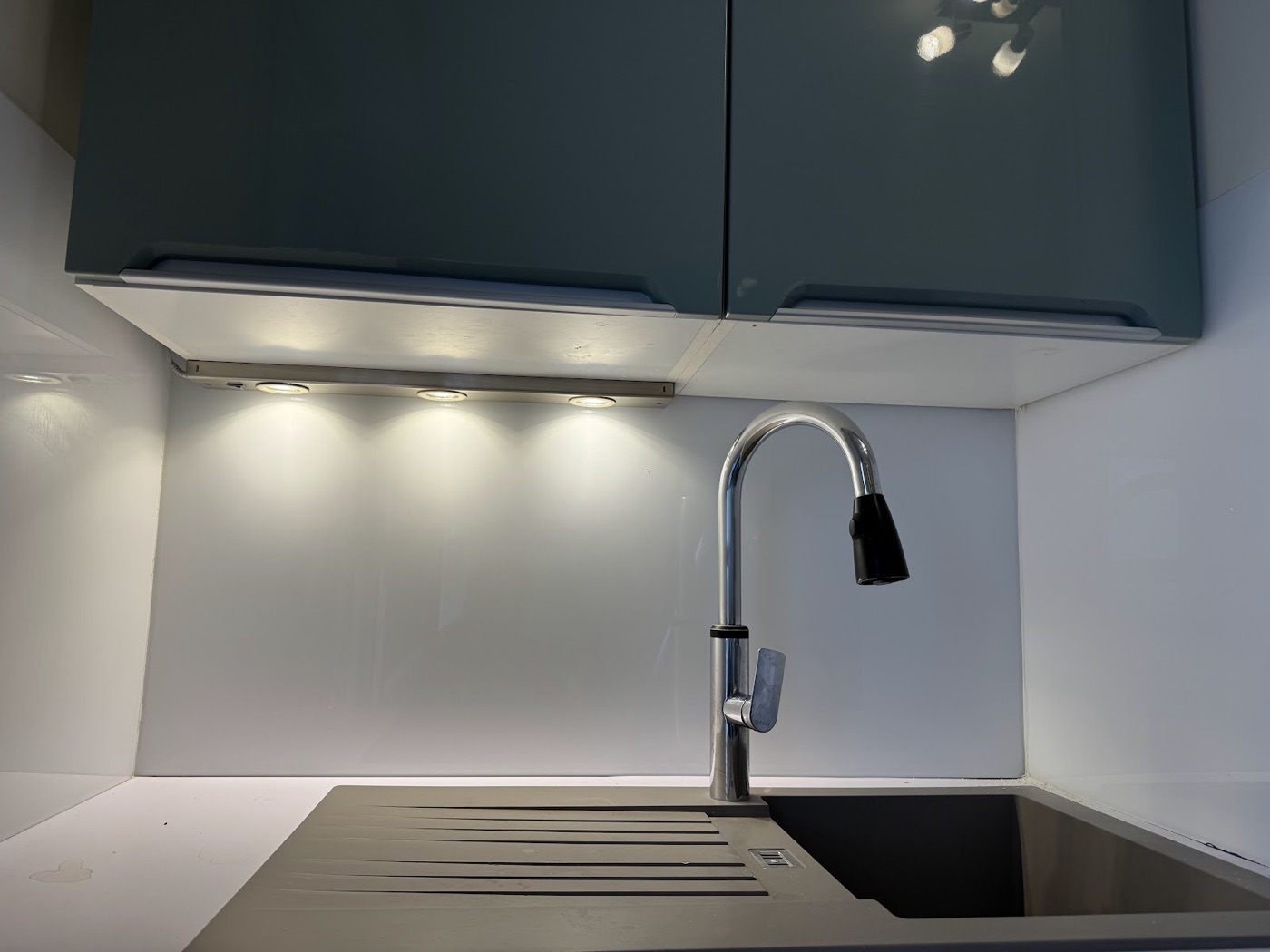 Éclairage LED sous meubles hauts au-dessus de l'évier d'une cuisine rénovée